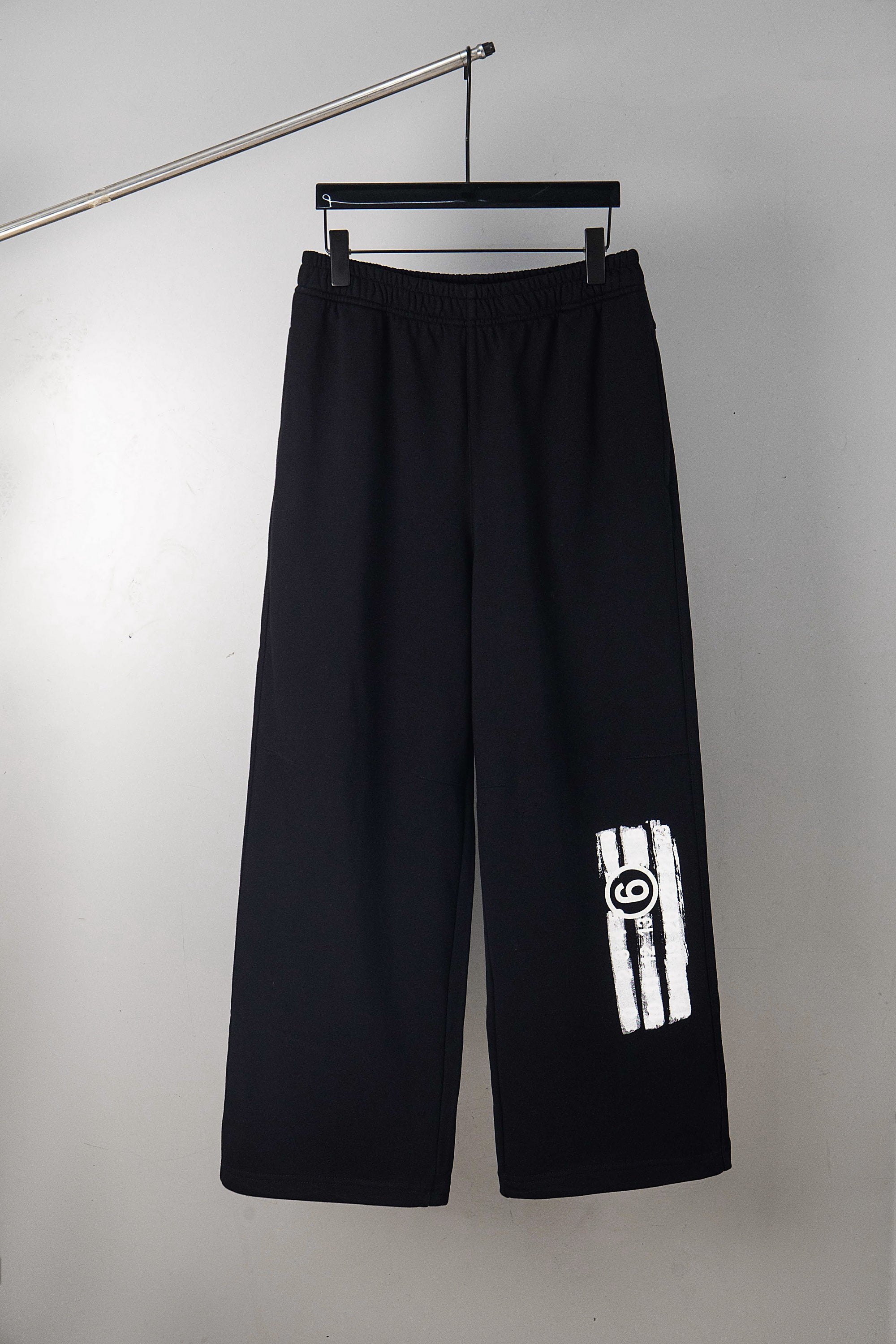Black wide-leg pants with side logo patch on the right leg