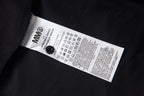 MM6 care label on black fabric