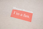 Beige T-shirt close-up with 'I'm a fan' logo patch