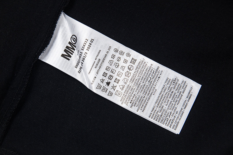 Clothing label inside black T-shirt with care and size information