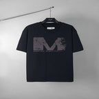 Black graphic T-shirt with large distressed M logo print