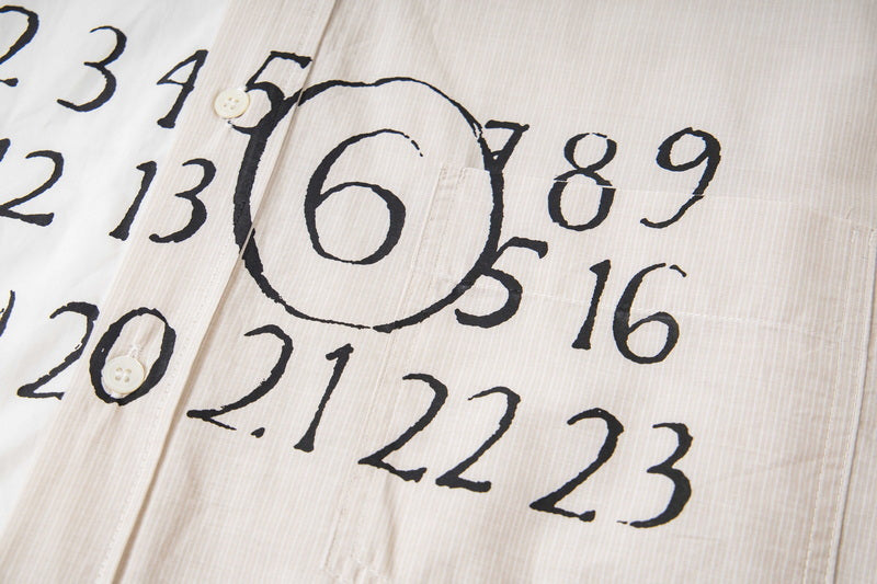 Close-up of white shirt fabric with black number graphic and circle details