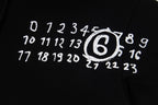 Close-up of black hoodie with white printed number graphic and emblem