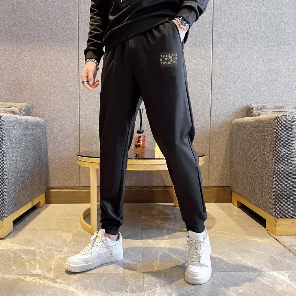 Black jogger pants with small logo label on thigh and cuffed hems