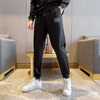 Black jogger pants with small logo label on thigh and cuffed hems