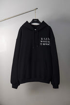 Black Maison Margiela pullover hoodie with drawstring hood and printed number logo