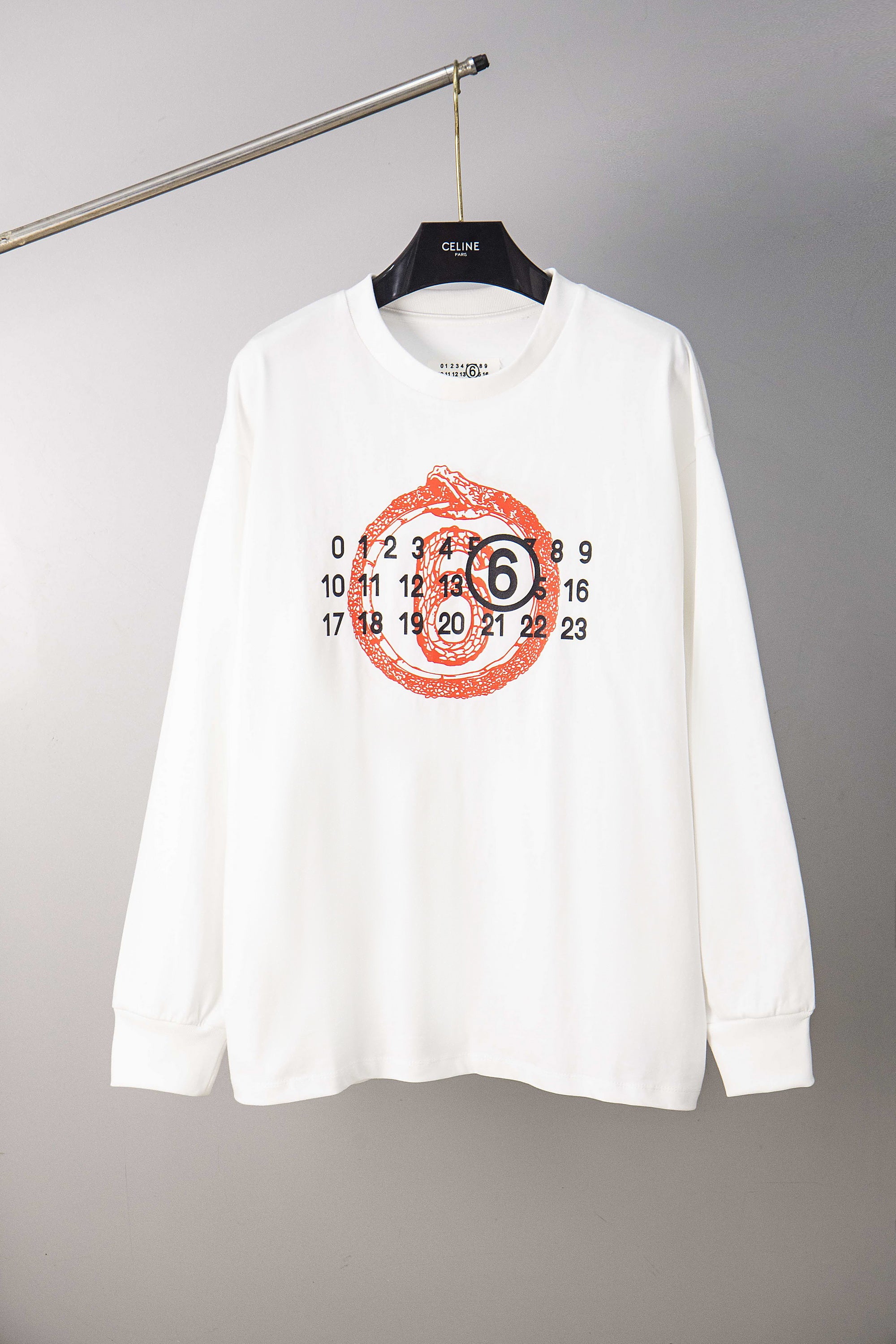 White long-sleeve T-shirt with red number graphic and round emblem on chest