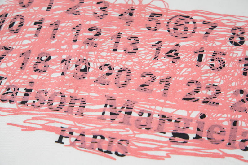 Pink and black numeric scribble graphic print on a white T-shirt front