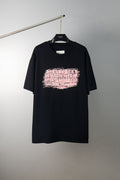 Black T-shirt with pink graphic logo print on the front, crew neck style