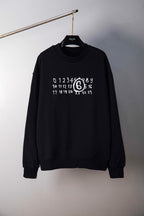 Black crewneck sweatshirt with numbered ring graphic, hanging view