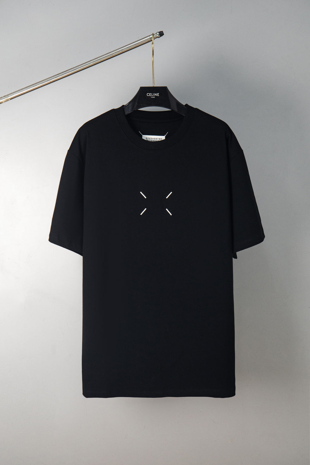 Black crewneck T-shirt with small dash graphic on the chest