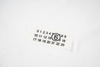 Maison Margiela fabric label with circled 6 logo and number grid