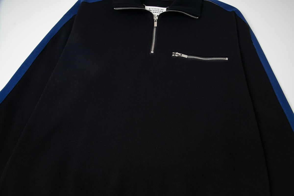 Black quarter-zip pullover with small chest zipper pocket detail