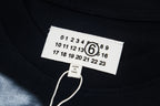 Close-up of black T-shirt neckline tag with numeric logo