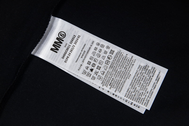 Close-up of black T-shirt care label with barcode and icons