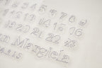 Close-up of light fabric with embossed numeric logo print
