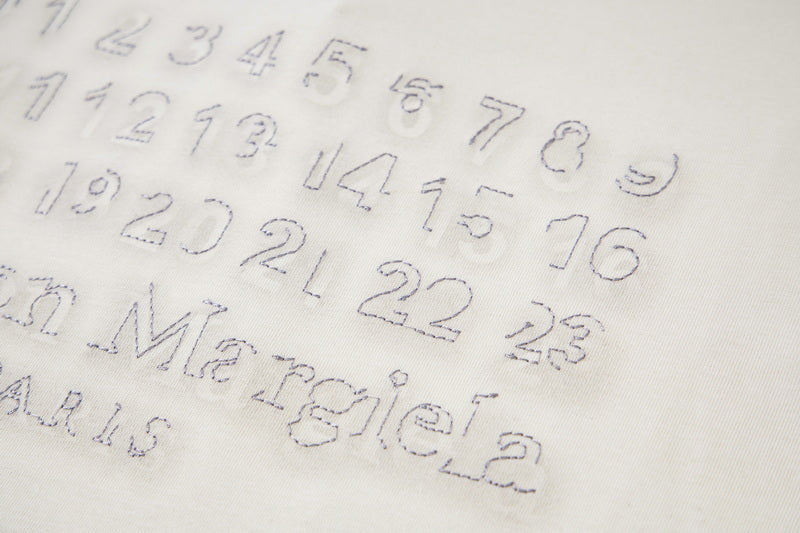 Close-up of light fabric with embossed numeric logo print