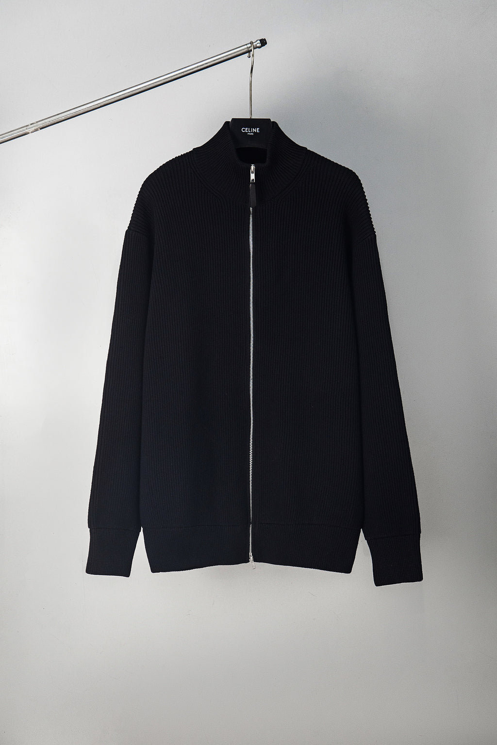 Black zip-front knit jacket with stand collar and long sleeves