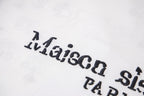 Close-up of black graphic lettering on a white T-shirt