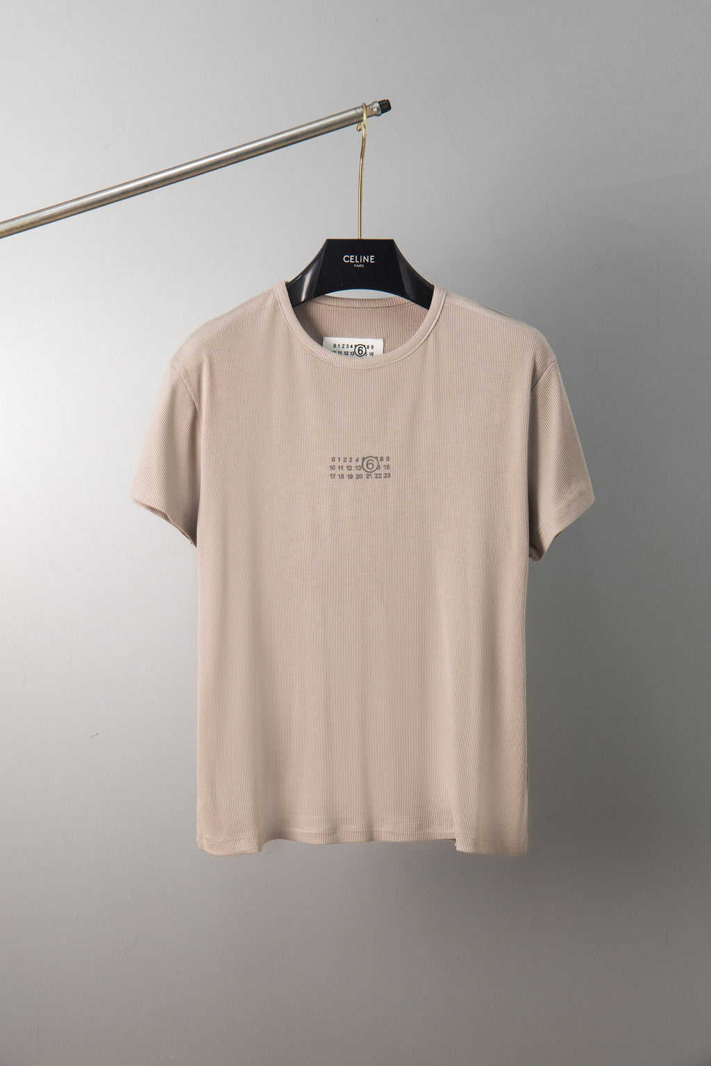Beige crew-neck T-shirt with small chest graphic, short sleeves