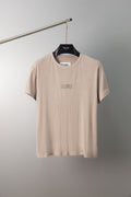 Beige crew-neck T-shirt with small chest graphic, short sleeves