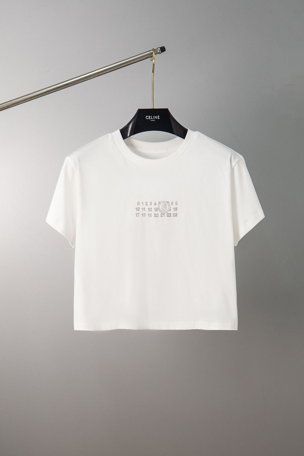 White graphic crewneck T-shirt on hanger with small number print on chest