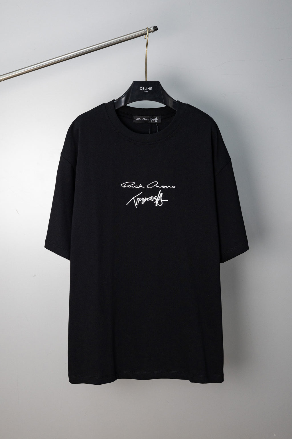 Black crewneck T-shirt with small script logo graphic at chest