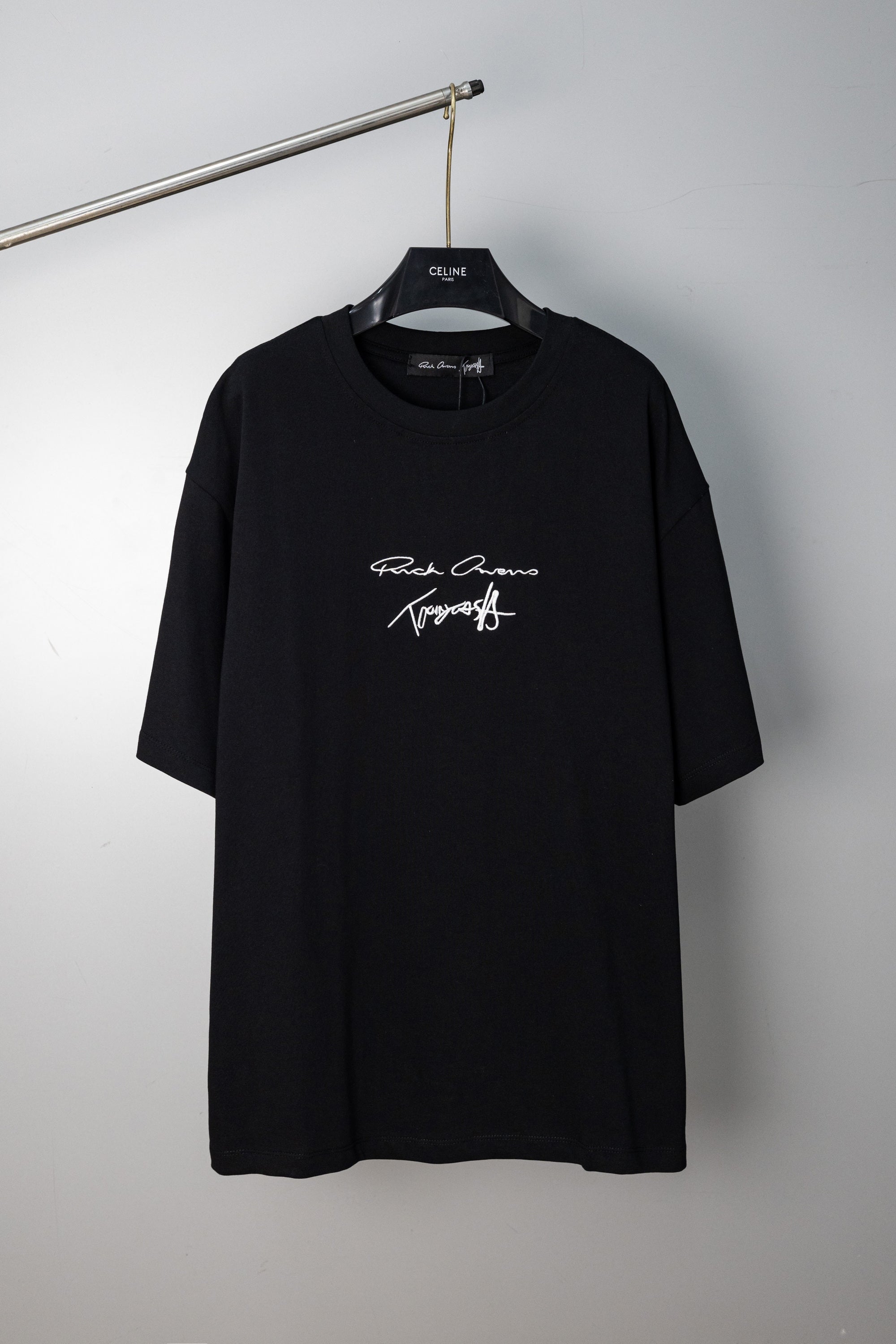 Black crewneck T-shirt with small script logo graphic at chest