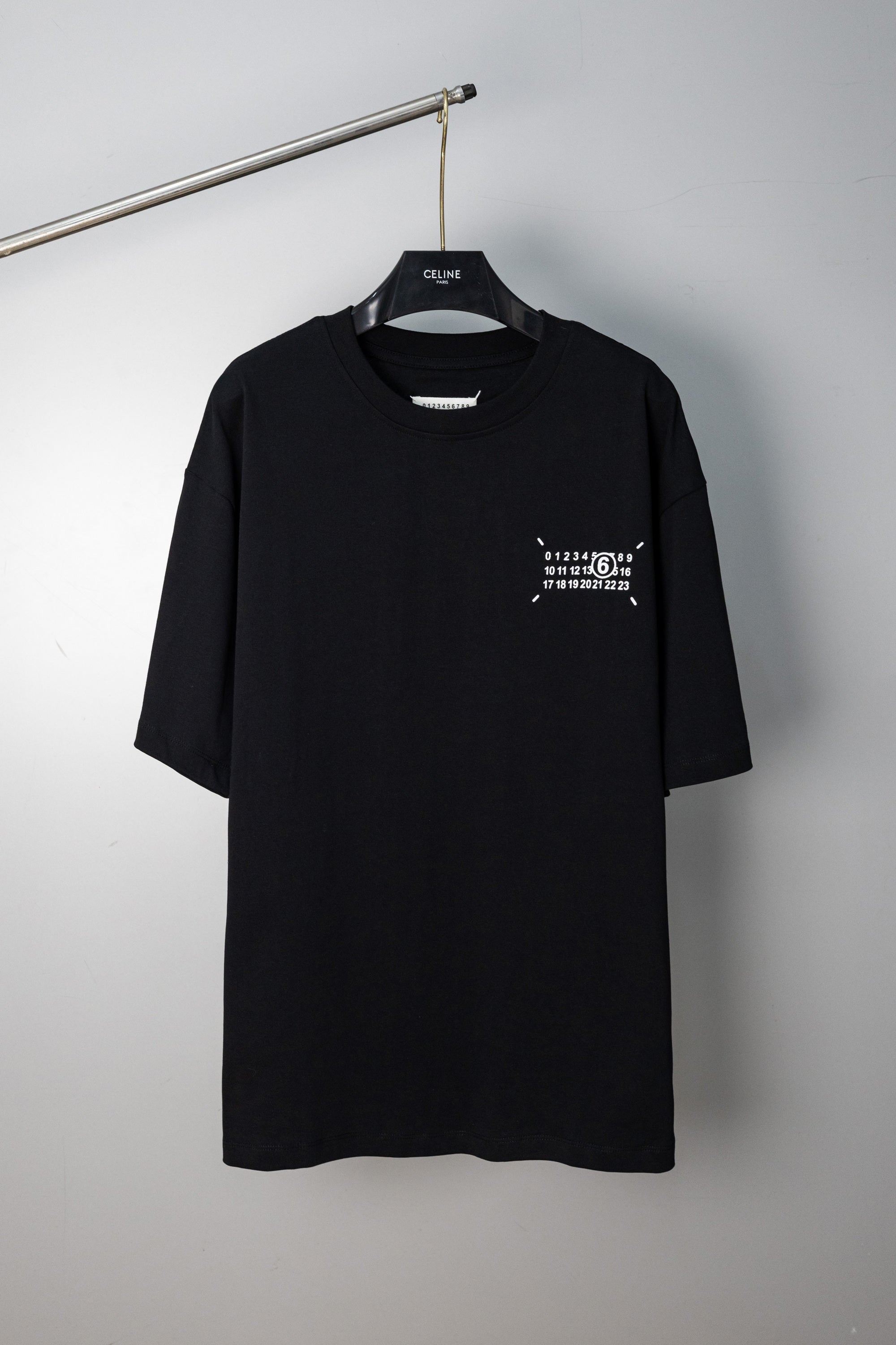 Black crew-neck T-shirt with small front numeric graphic print and short sleeves