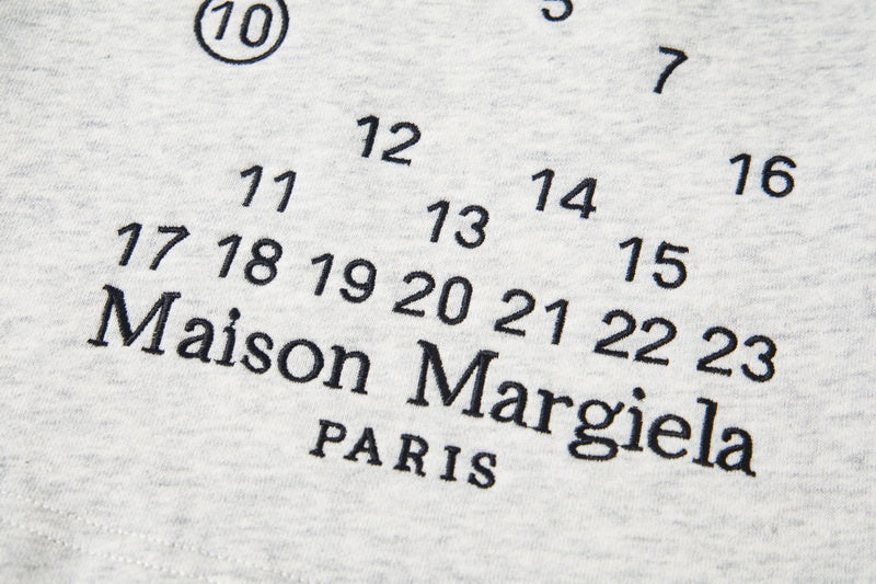 Close-up of Maison Margiela Paris logo with scattered number graphic on fabric