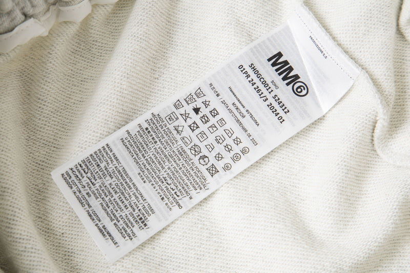 Close-up care label inside white shorts with washing and recycling symbols