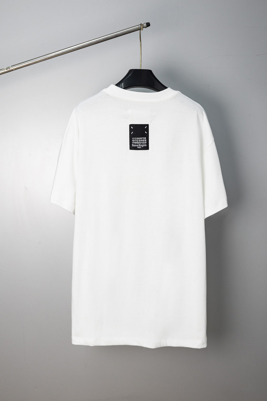 White crew-neck T-shirt with small logo label at the back neckline