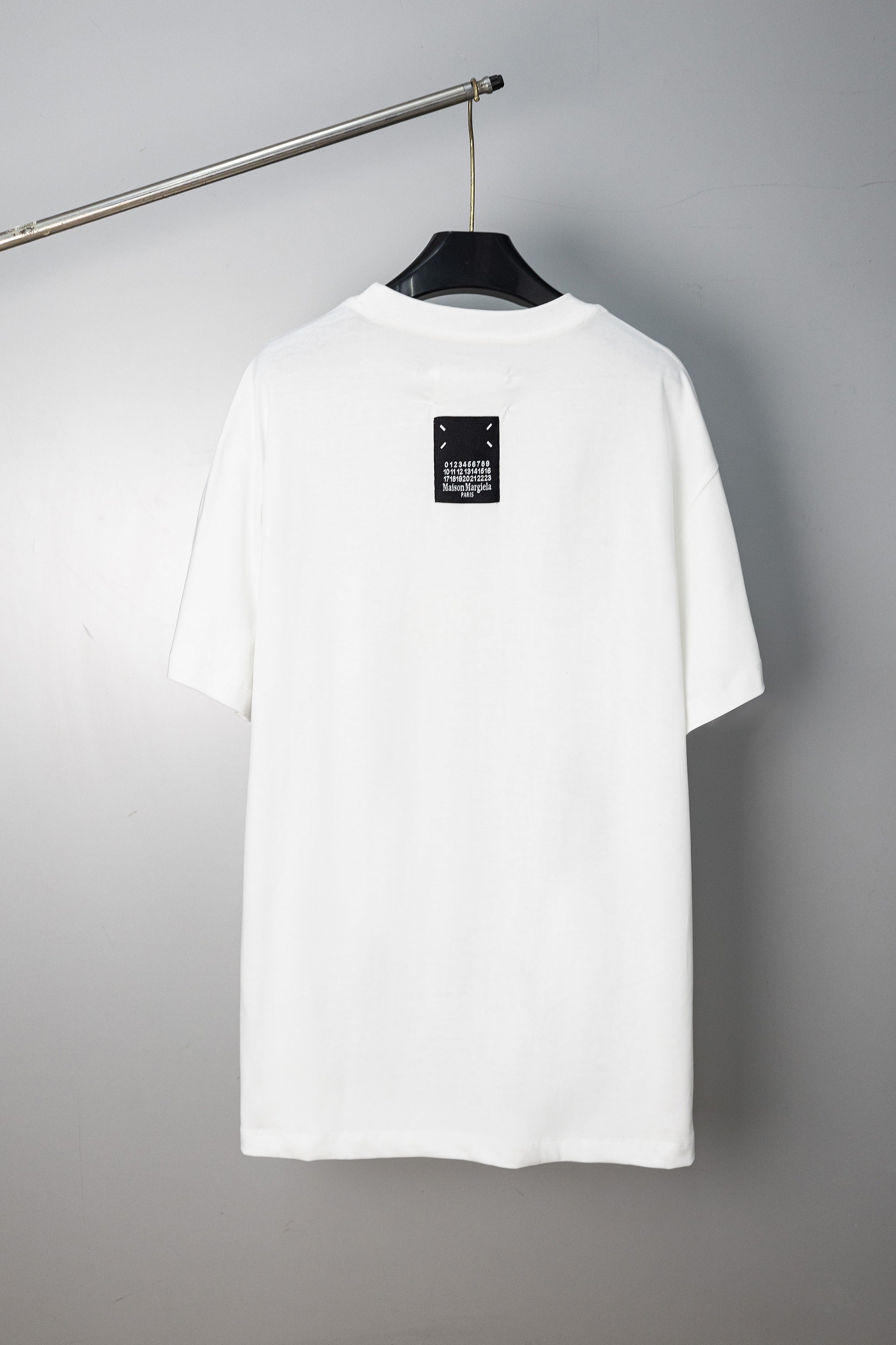 White crew-neck T-shirt with small logo label at the back neckline