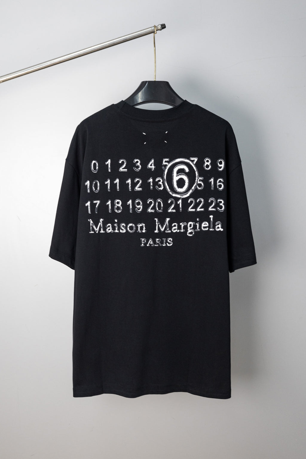 Black T-shirt with “Maison Margiela Paris” number 6 graphic print at chest