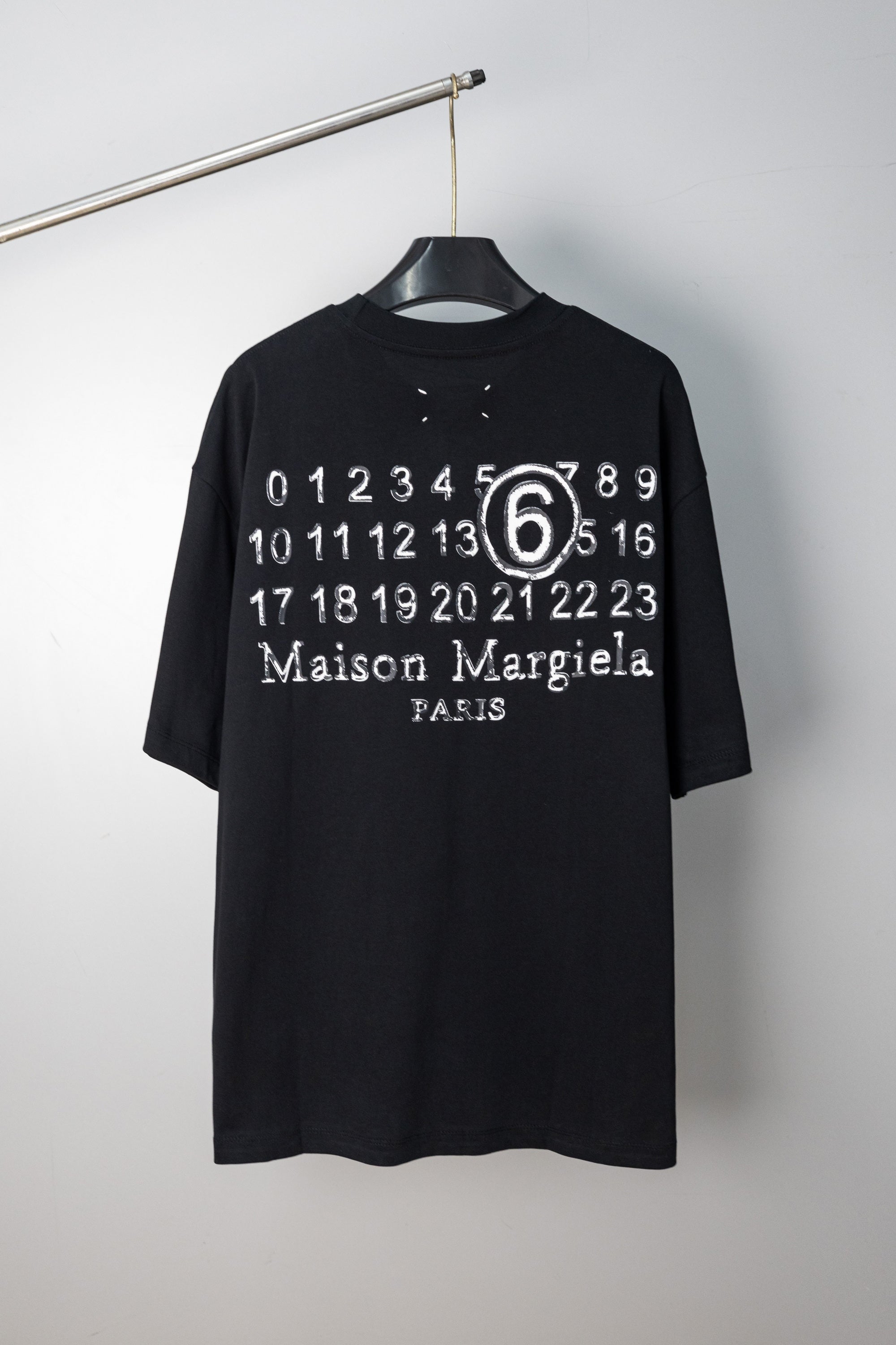 Black T-shirt with “Maison Margiela Paris” number 6 graphic print at chest
