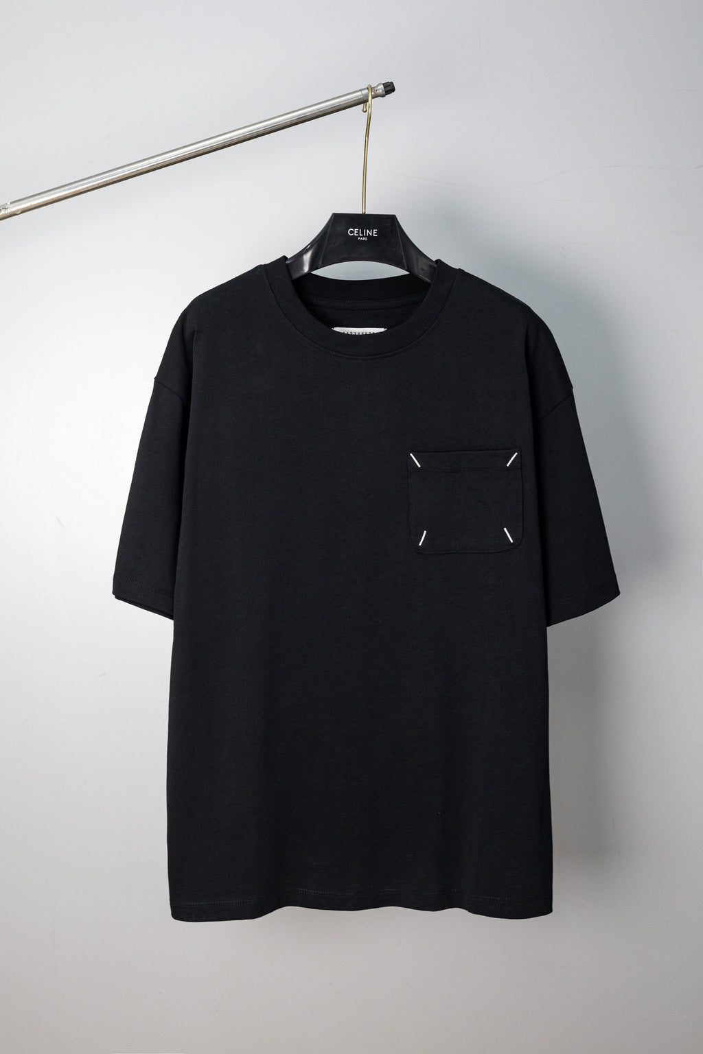Black crew-neck T-shirt with small stitched emblem on chest