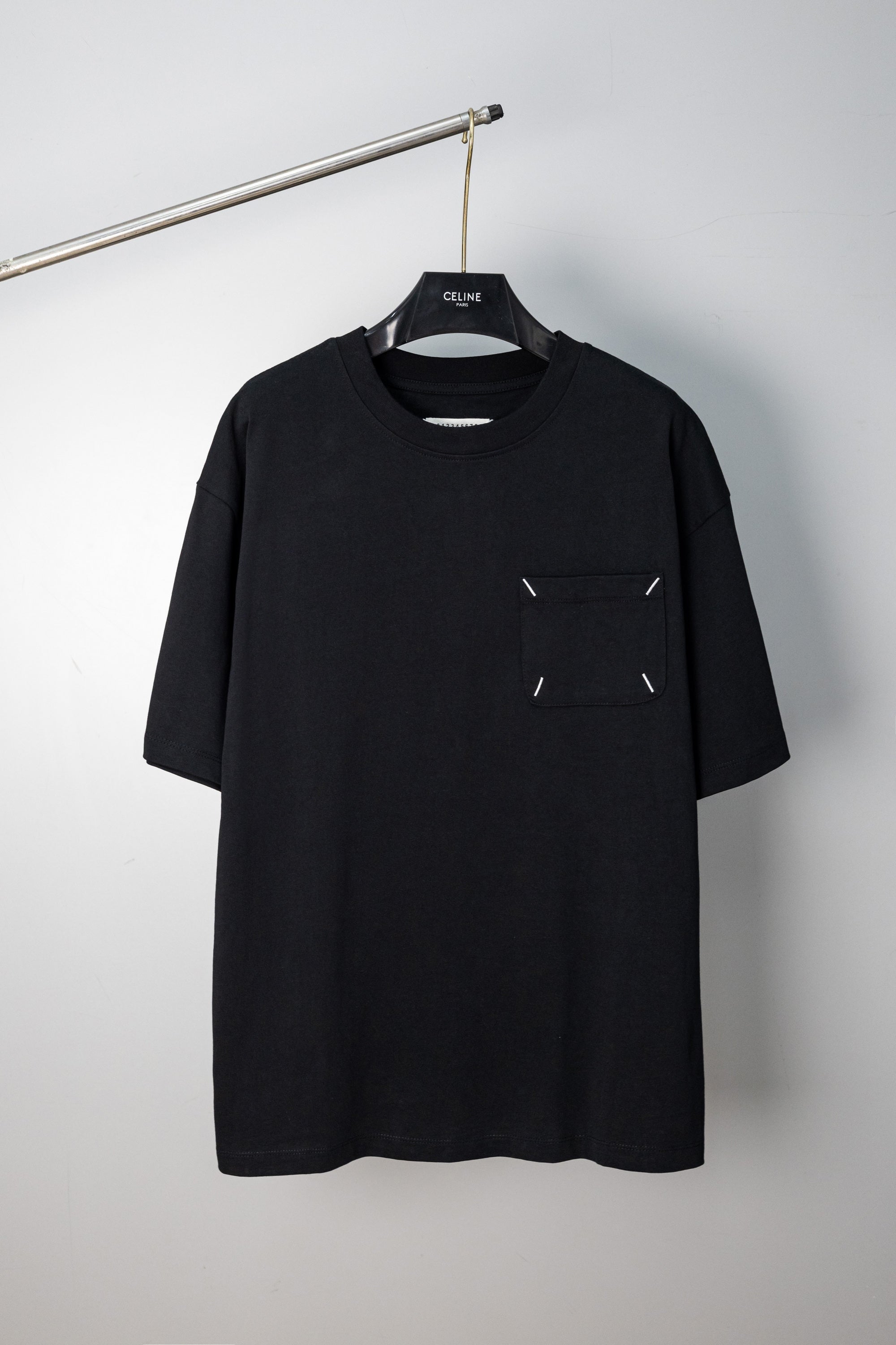 Black crew-neck T-shirt with small stitched emblem on chest