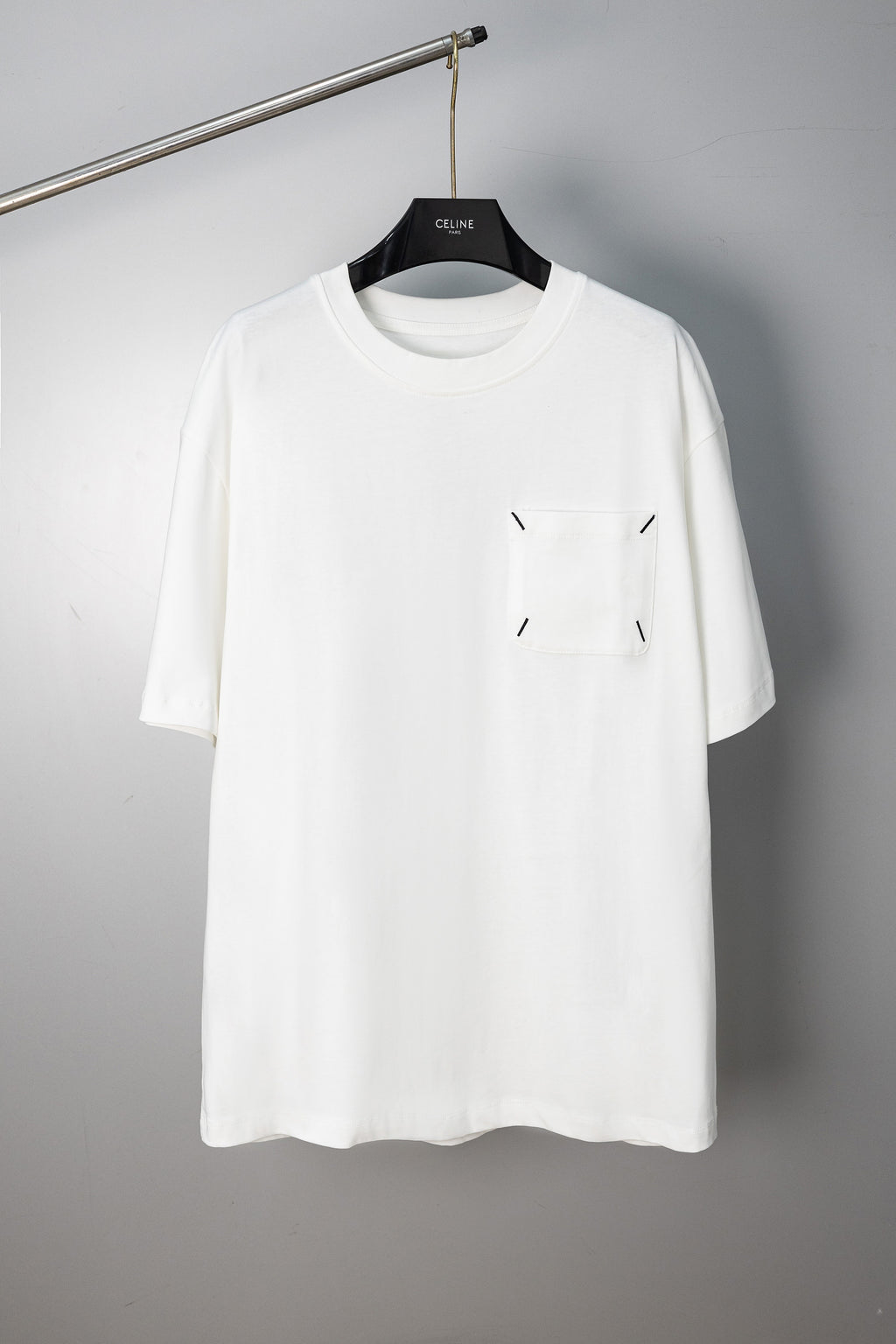 White crew-neck T-shirt with small stitched emblem on chest