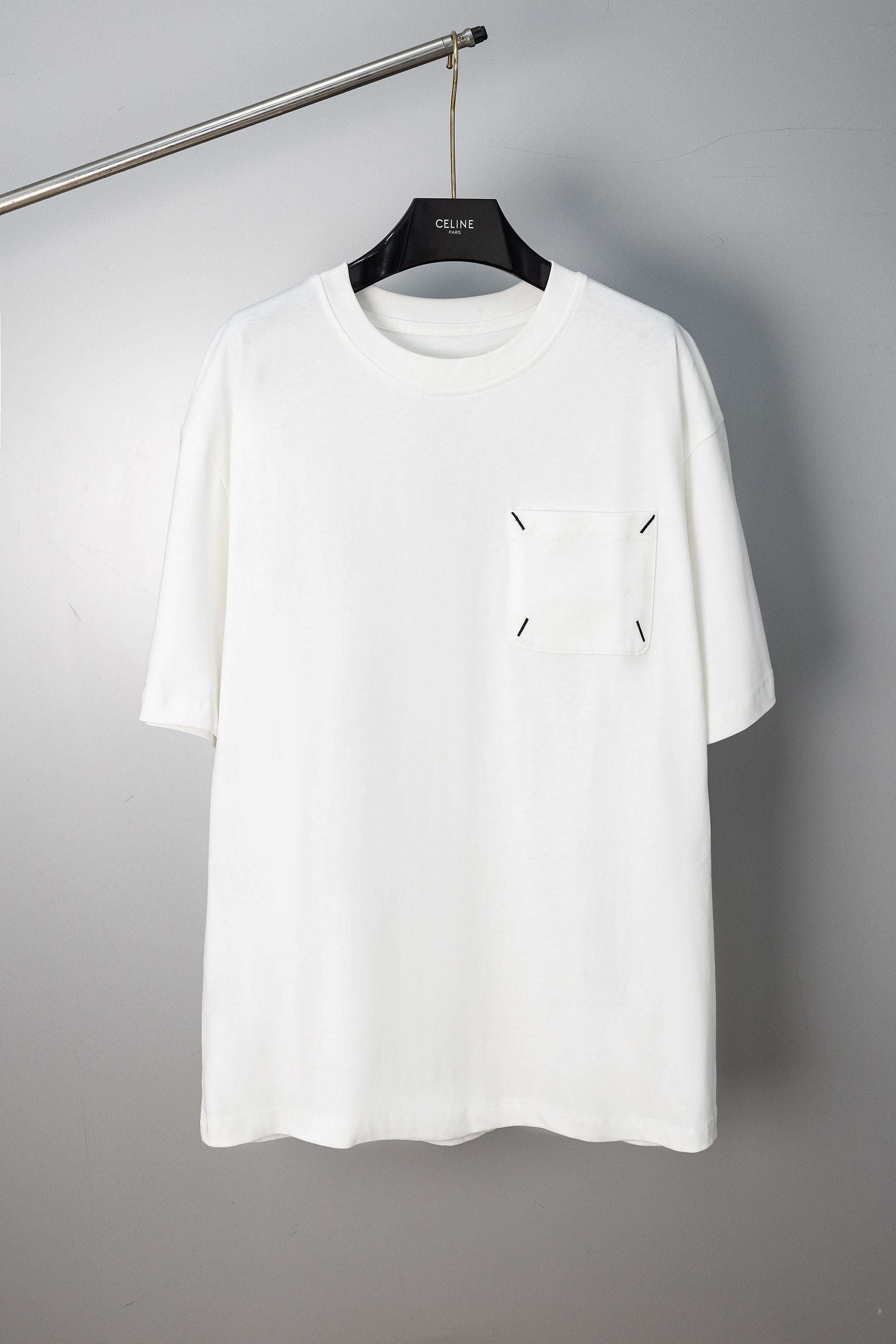 White crew-neck T-shirt with small stitched emblem on chest