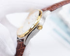 Longines wristwatch side view with crown and polished case, brown leather strap