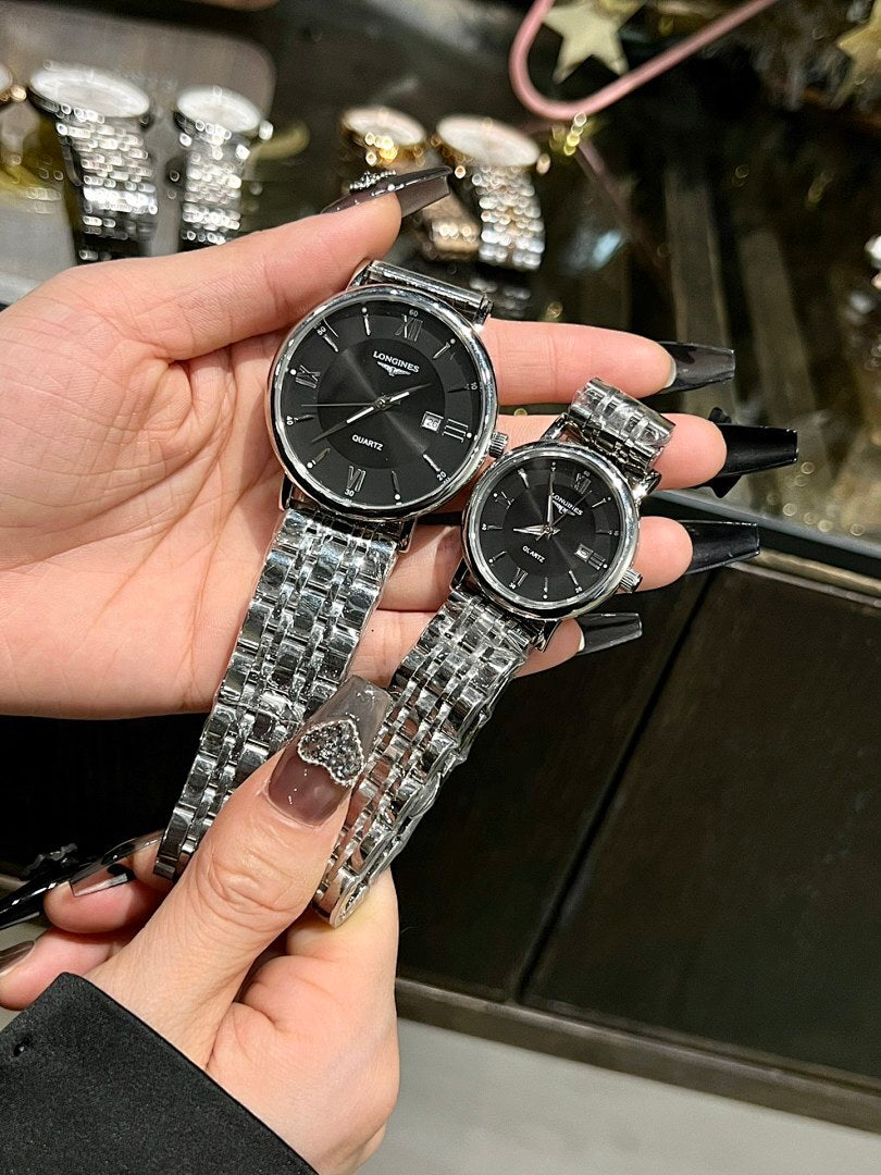 Two wristwatches with silver metal bracelets and black dials held in hand.