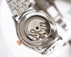 Open caseback of a stainless steel watch with visible mechanical movement
