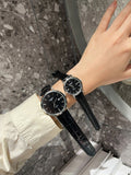 Longines watch with black dial and black leather strap on wrist, round case