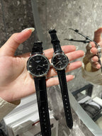 Longines watch with black dial and black leather strap, two round cases on hand