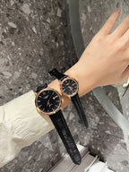Longines watch with black dial and black leather strap on wrist, round case