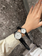 Longines watch with white dial and black leather strap on wrist, round case