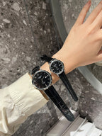 Longines watch with dark dial and black leather strap on wrist, round case