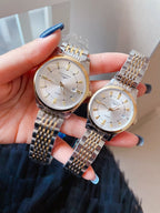 Two round stainless steel wristwatches with light dials and metal link bracelets, close-up