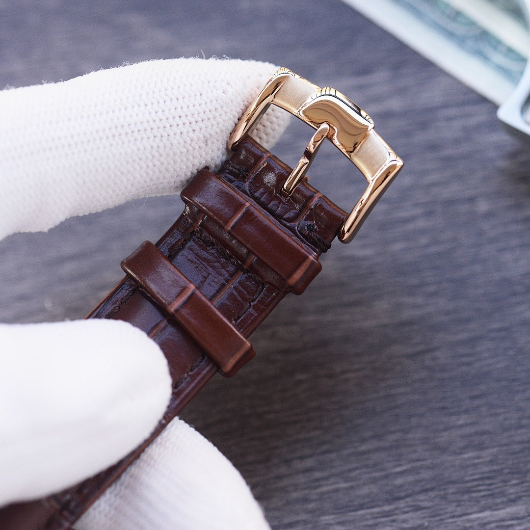 Leather strap wristwatch with gold-tone buckle and dark brown strap, side view