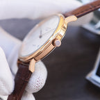 Quartz wristwatch with white dial, gold-tone case, and dark brown leather strap, side view